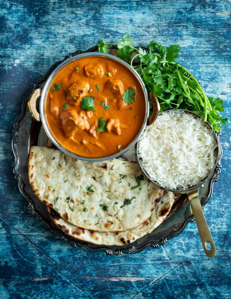 Butter chicken with a side of naan and rice